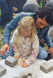 Das Bild zeigt ein Kind beim Mehlmahlen.