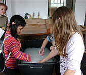 Das Bild zeigt Kinder beim Papiersch�pfen.