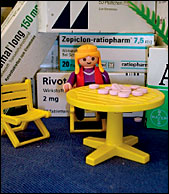 M�nnchen umgeben von gro�en Tablettenpackungen