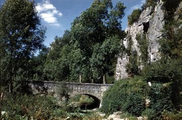 Sieben Jungfrauen: Kalksteinfelsformation im Hönnetal mit Blick auf eine alte Steinbogenbrücke
