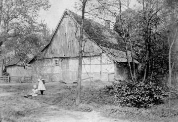 Kinder vor einem alten, strohgedeckten Haus in Westbevern