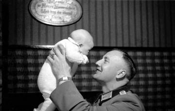 Soldaten im Heimaturlaub, Veterinär Hubert Stenert mit einem Säugling