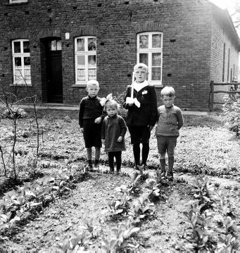 Kommunionkind und Geschwister der Familie Hoffjan vor dem Haus