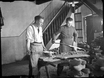 Holzschuhmanufaktur: Arbeiter beim Schlichten des Aussenschuhs mit dem Pfahlmesser