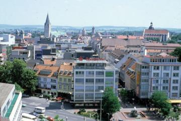 Blick vom Turm der Herz-Jesu-Kirche auf das Westerntor und die Westerstraße, vorne rechts der "Brunnen am Westtor", auch Rikus-Brunnen genannt, im Hintergrund links der Paderborner Dom. 