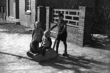 Kinder mit einem Schlitten vor Haus Kösters (eventuell Schneiderei Brömmel?), Marbecker Straße