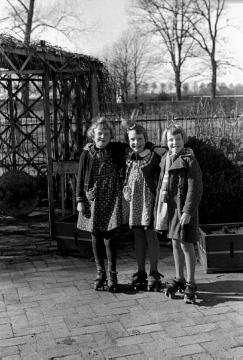 Kinder aus dem Dorf mit Rollschuhen auf dem Hof Böckenhoff: Gisela Heller, Thea Seier und Hanni Büsken