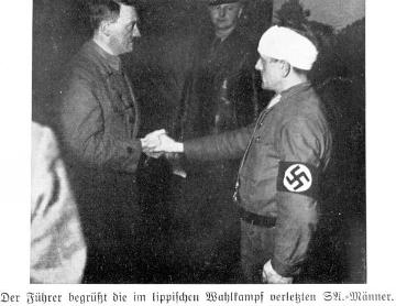 Nationalsozialismus: Adolf Hitler begrüßt einen im lippischen Wahlkampf 1933 verletzten SA-Mann