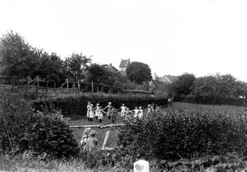 Spielende Kinder am Dorfrand von Schapdetten - im Hintergrundf die Turmspitze der St. Bonifatius-Kirche von Süden