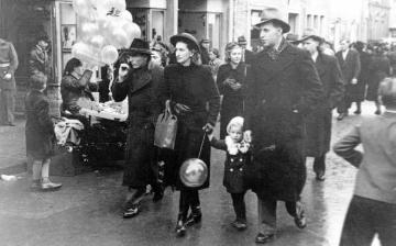 Heinrich Josef Hornkamp (1916-2001, Bahnbeamter) mit Ehefrau Luise (geb. Reinold, 1914-2005) und Sohn Dietmar auf einer Geschäftsstraße in Unna (?), undatiert, Ende 1940er Jahre