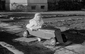 Die Nottulner Fabrikantenfamilie Rhode: Kind mit Spielzeugrennwagen im Garten von Villa Rhode, undatiert, Ende 1940er Jahre?