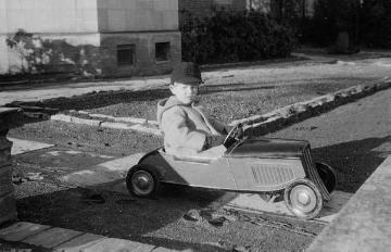 Die Nottulner Fabrikantenfamilie Rhode: Kind mit Spielzeugrennwagen im Garten von Villa Rhode, undatiert, Ende 1940er Jahre?