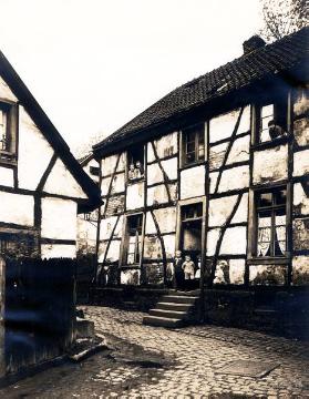 Enge Gasse mit baufaufälligem Fachwerkhaus, Ort unbekannt, undatiert, 1920er Jahre