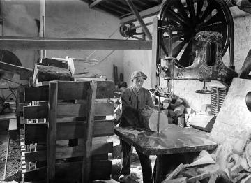 Holzschuhmanufaktur, Sägewerk: Arbeiter an der Bandsäge beim Spalten von Stammstücken