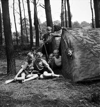 Zeltlager der katholischen Pfarrjugend mit Kaplan Jasper,  Jungen vor einem Zelt