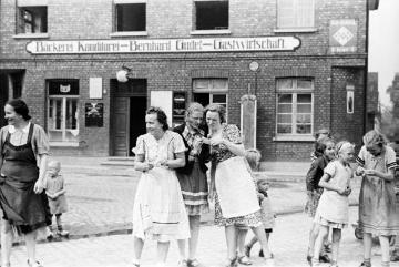 Nach der Durchfahrt eines SS-Truppenverbandes: Frauen und Mädchen lesen abgeworfene Zettel der Soldaten (Änne Ostendorf, Magda Hüppe, Mathilde Ostendorf, Cilly Friedrich und Maria Gudel)