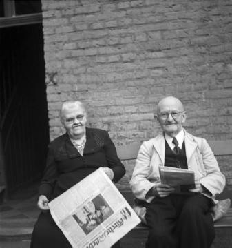 Eheleute Emilie und Antonius Indewal bei der Zeitungslektüre im Hof - Raesfeld, Weseler Straße, um 1950.