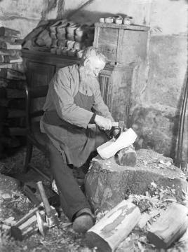 Holzschuhmacher beim Ausformen eines Rohlings mit dem Schlagbeil ('Dexel')