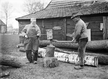 Holzschuhmacher beim Spalten von Holzblöcken mit Axt und Holzhammer