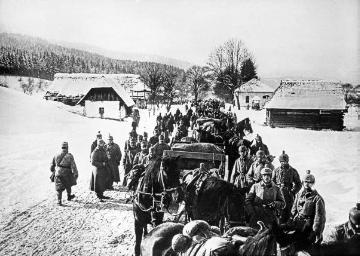 Kriegsschauplatz Galizien/Rumänien um 1917: Deutsch-österreichische Militärkolonne durchquert ein Dorf in den verschneiten Karpaten