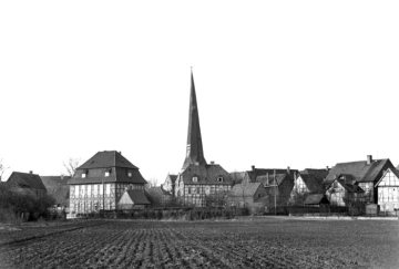 Delbrück-Ortszentrum um 1952: Pastorat (links) mit angrenzendem Pastoratsacker (Wiemenkamp), Kirchturm von St. Johannes Baptist und Haus Dr. Schmidtmann (Bildmitte), später Heimathaus. 