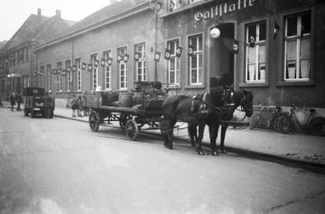 Marktplatz Hamm in Richtung Widumstraße. Rechts: Brauereikutsche vor dem Gebäude der Klub-Gesellschaft ("Hitler-Platz" 5) mit Hakenkreuzbeflaggung. Undatiert, um 1936 [vgl. Bild-Nr. 17_1792 vom gleichen Tag].