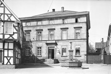 Herdecke, Hauptstraße 1/1a: Fachwerkhaus von 1583 (links) und Apotheke Becker am Kornmarkt - vorn: der 1937 aufgestellte Sackträgerbrunnen. Undatierte Vermessungsdokumentation der damaligen "Adolf-Hitler-Straße" [nach 1937].