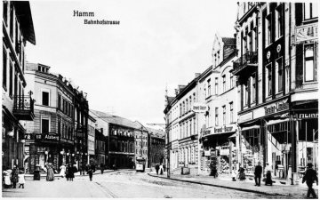 Hamm - Bahnhofstraße mit Straßenbahnverkehr (Trassenbau ab 1898). Links: Bekleidungsgeschäft Gebrüder Alsberg an der Mündung Luisenstraße. Rechts: Ladenlokal S. Richter "Grand Bazar" und E. Hauckmann "Tapeten.Linoleum". Postkarte, undatiert, um 1910 [?].