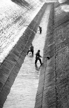 Städtische Bedienstete bei der Säuberung der Kanalwände des Landwehrbachs, Nebengewässer der Emscher bei Castrop-Rauxel, in Funktion als Schmutzwasserkanal. Februar 1987.
