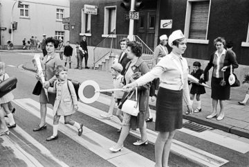 Erstklässler auf dem Weg zur Einschulung: Schülerlotsin sichert den Übergang über die B235, Wittener Straße in Castrop-Rauxel-Merklinde. August 1968.