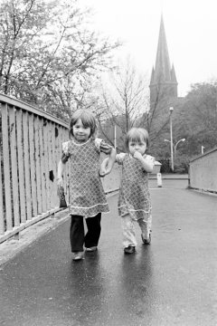 Kleines Schwesternpaar auf der Brücke über die Emschertalbahn. Castrop-Rauxel, April 1980. Im Hintrgrund: Turm der Lambertikirche.