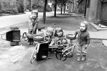 "Boxenstop" - Kleinkinder "reparieren" ihre Tretautos. Castrop-Rauxel, Lambertus-Platz. April 1981.
