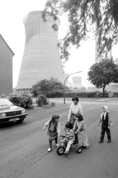 Spielende Kinder in einer Werkssiedlung in Castrop-Rauxel-Habinhorst, Juni 1984. Im Hintergrund: Kühlturm des Klöckner-Kraftswerks.
