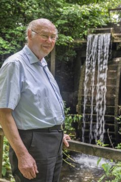 Professor Dr. Anton Janßen, Gründungsmitglied des Mühlen- und Heimatvereins Leer, porträtiert 2019 vor Wennings Mühle in Horstmar-Leer (Standort Ostendorf 60)