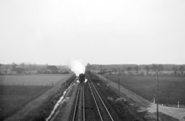 Güterzug mit Dampflokomotive der Baureihe 50 auf der Fahrt Richtung Hamm, 1966 - fotografiert von einer Brücke 2 km nördlich des Bahnhofs Rinkerode. Links Pachthof von Droste zu Vischering.