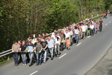 Osterfeuerbrauch in Attendorn: Transport des Baumstammes für das Osterkreuz durch die Poskebrüder des Osterfeuervereins Waterpoote