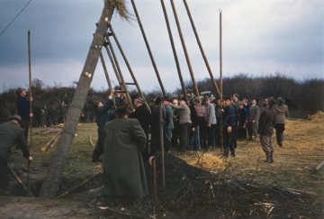 Osterfeuerbrauch in Attendorn: "Poskebrüder" des Osterfeuervereins beim Aufrichten eines Osterkreuzes mittels langer Stangen