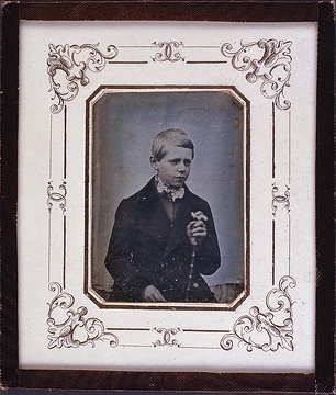 Unbekannter Junge mit Spazierstock vor weißem Tuch. Daguerreotypie (Friedrich Hundt zugeschrieben).