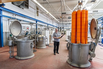 Schmitz Textiles GmbH & Co. KG: In der Färberei, nach dem Färben. Mitarbeiter Udo Kohnert versenkt die frisch gefärbten Garnrollen in den Druckbehältern zur Trocknung.