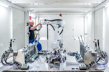 Lotte, FRIMO Group GmbH: Ultraschallschneidanlage für Türverkleidungen, Andre Buchholz während letzter Kontrollarbeiten am Schneidroboter.