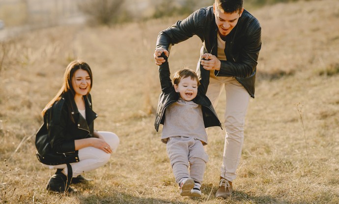 Foto Eltern mit ihrem Kind beim Spielen auf einer Wiese (Bild: pexels/Gustavo Fring).