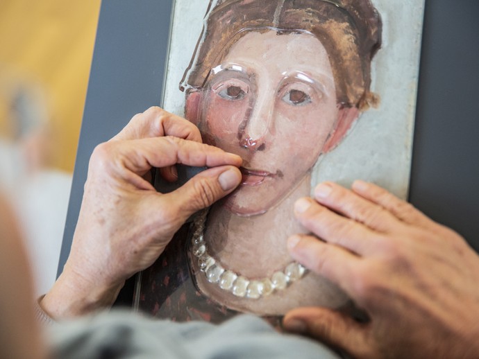 Frau ertastet ein Tast-Bild mit ihren Händen Frau ertastet ein Tast-Bild mit ihren Händen