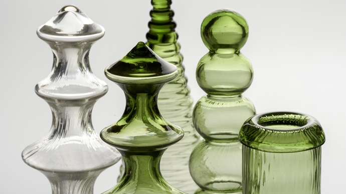 Detailansicht verschiedener Flaschen und Glasfiguren, in grün und weiß gehalten