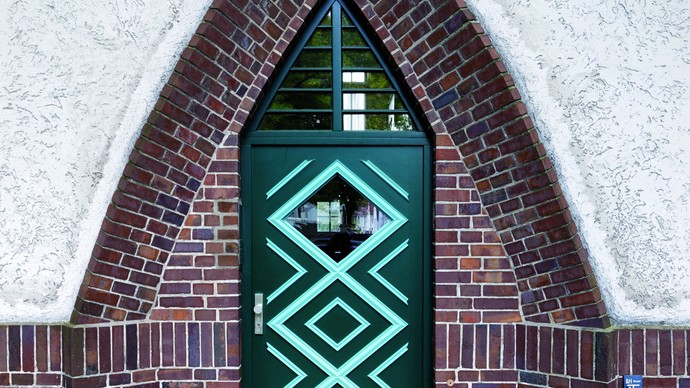 Blick auf Haustür, von Spitzbogen aus Backstein umgeben
