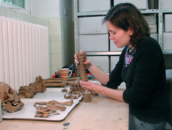 Anthropologin sitzt an einem Tisch und f�gt menschliche Wirbel zusammen. Foto: LWL/R. Klostermann. 