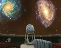 Planetariumsger�t mit Galaxien im Hintergrund