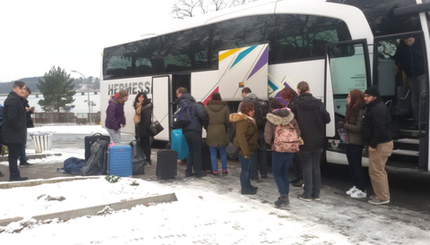 Viele Personen mit Reisegepäck vor einem Reisebus
