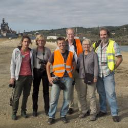 Eine Gruppe von Menschen steht vor einer Industrieanlage und posiert für ein Foto. (vergrößerte Bildansicht wird geöffnet)