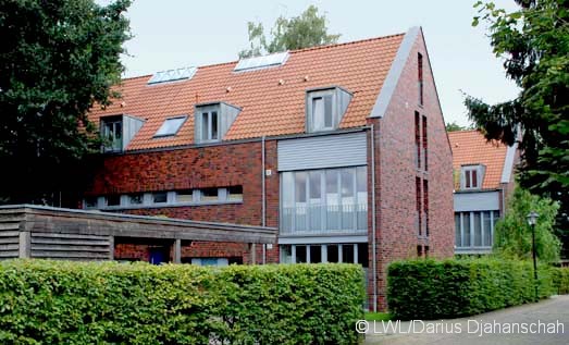Blick auf die Gebude mit Carport und Hecken