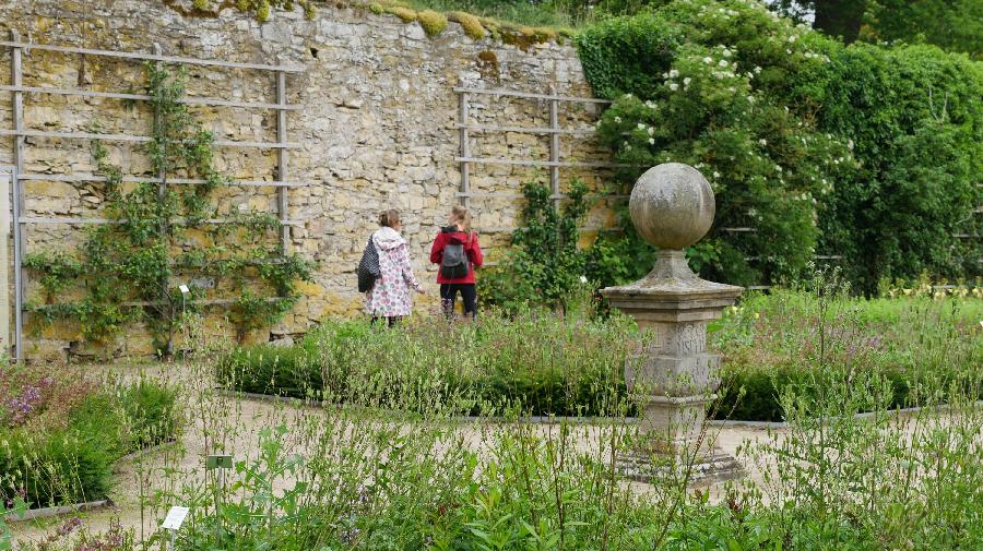 Besucher im Garten vor der Klostermauer